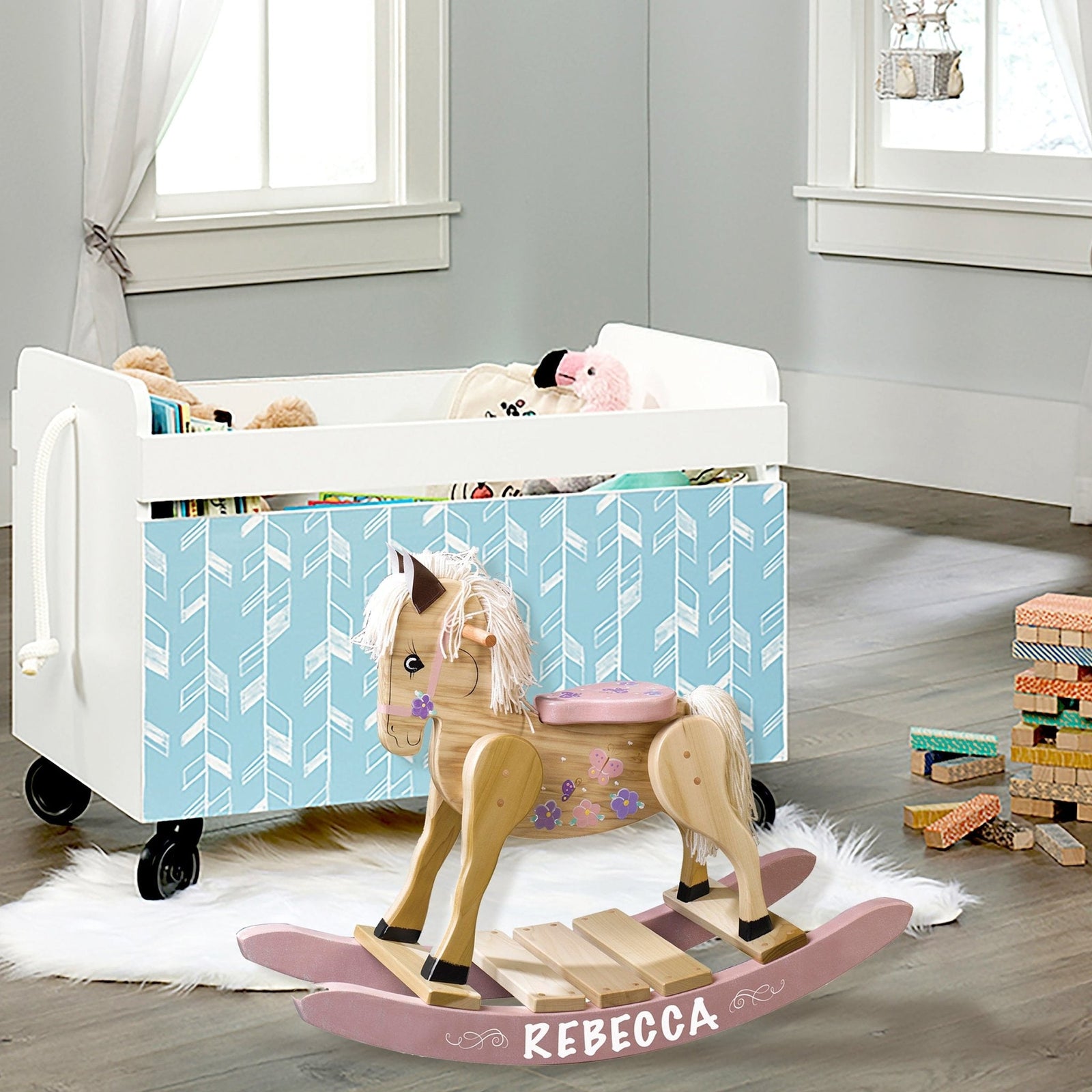 Personalized rocking horse beside white crib in nursery
