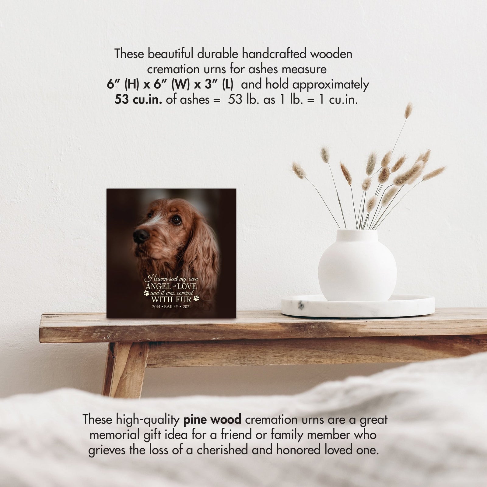 A wooden pet urn with size details, highlighting its handcrafted design with a white vase of pampas grass.
