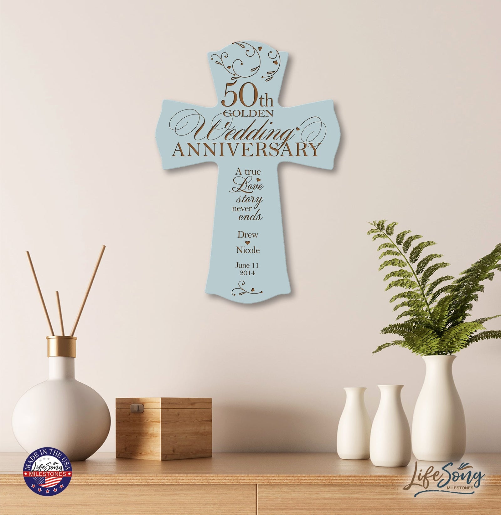 Light blue 50th Golden Wedding Anniversary personalized cross plaque displayed on modern wooden shelf with vases—custom Christian wall décor with names and wedding date.