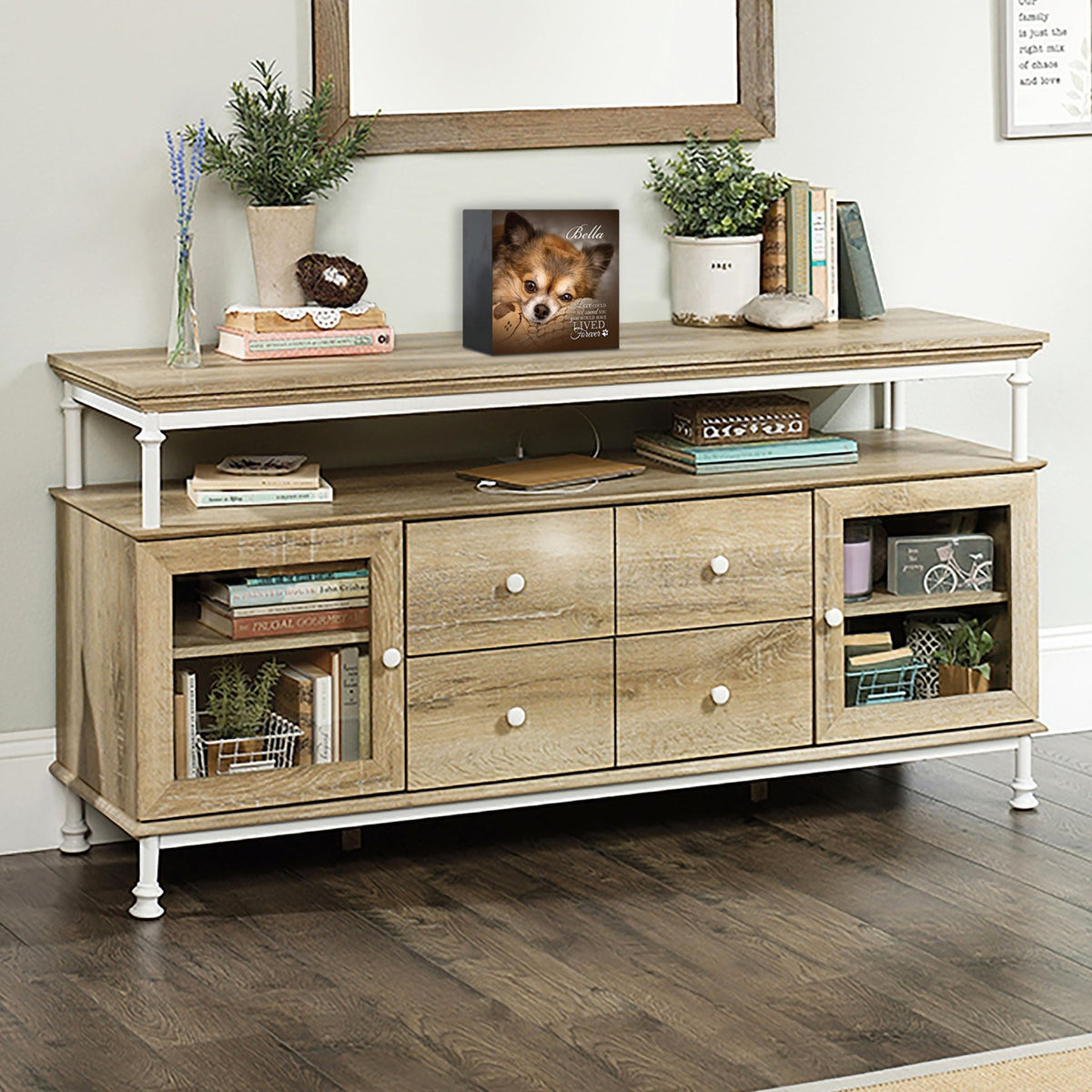 Wooden pet urn shadow box displayed on a rustic wooden TV console in a cozy living room. The shadow box features a custom photo of a dog named Bella with the text 'If love could have saved you, you would have lived forever.' A touching bereavement keepsake box ideal for memorial shadow box ideas and personalized pet urns for ashes.