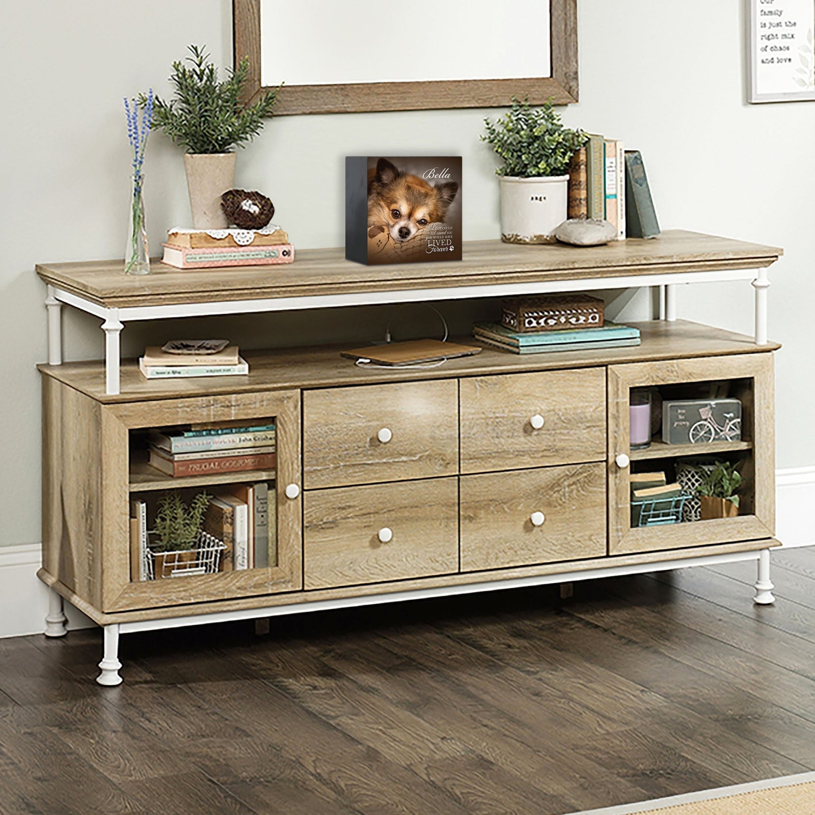 Wooden pet urn shadow box displayed on a rustic wooden TV console in a cozy living room. The shadow box features a custom photo of a dog named Bella with the text 'If love could have saved you, you would have lived forever.' A touching bereavement keepsake box ideal for memorial shadow box ideas and personalized pet urns for ashes.