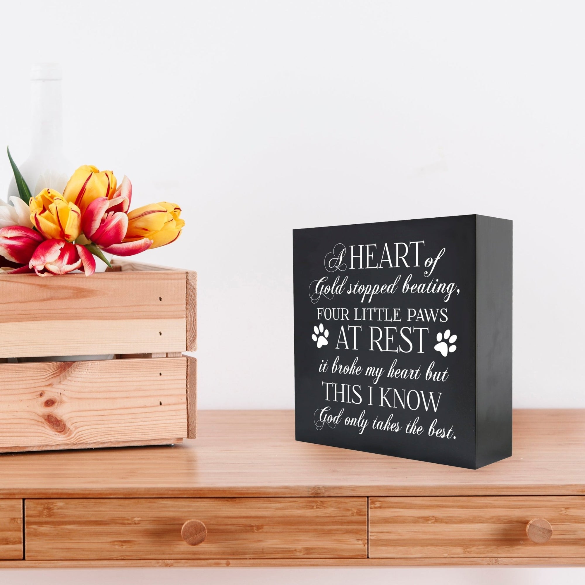 Black Lifesong Milestones Memorial Shadow Box Urn For Pet Ashes placed on a wooden table with a decorative setting, offering a meaningful way to honor a cherished dog or cat with an engraved sentimental quote.