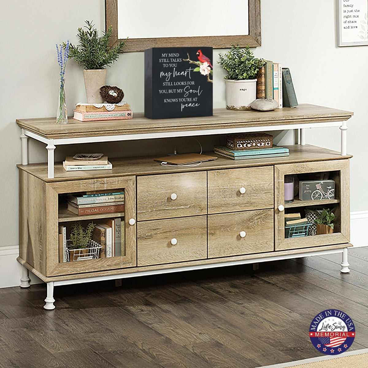 Elegant wooden shadow box urn for human ashes, designed to honor loved one’s memory. The urn is displayed on a rustic wooden console table, surrounded by books, plants, and a warm, inviting decor. Perfect for adult cremation keepsakes, combining functionality with heartfelt design.tive design, suitable for holding human ashes.