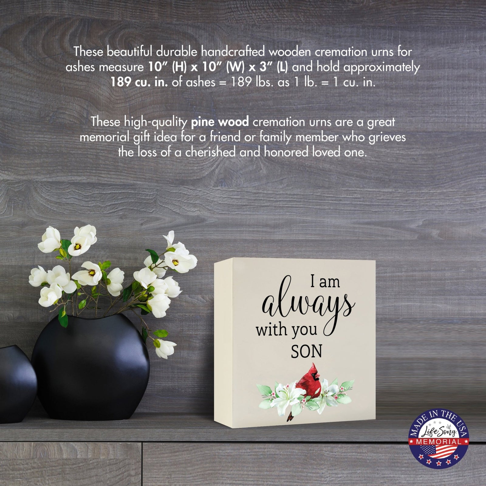 Cream-colored wooden shadow box urn for human ashes, measuring 6" x 6" x 3". The urn features a red cardinal and delicate floral design. Displayed on a wooden surface beside modern black vases with white flowers, this handcrafted urn is ideal for honoring adult loved ones.